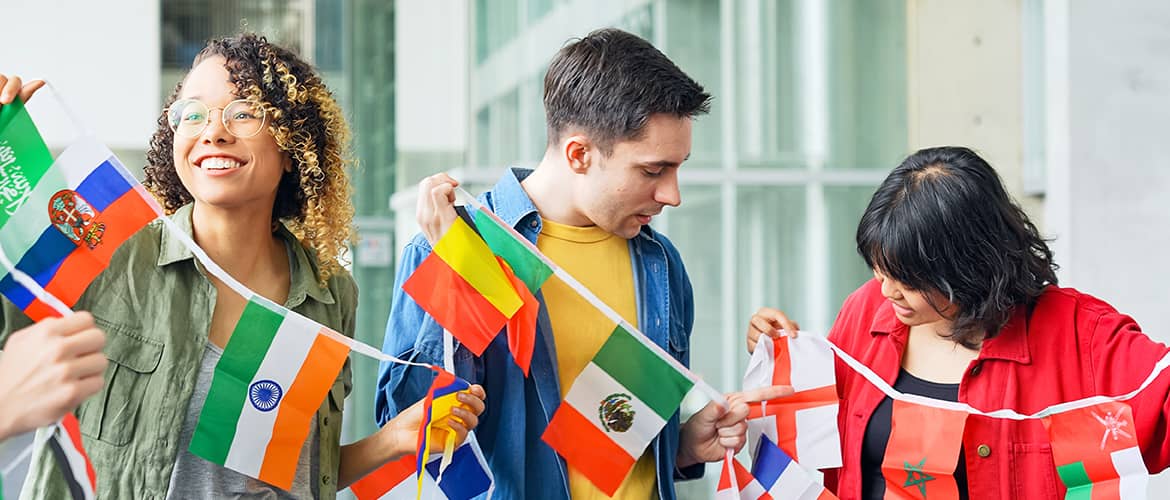 Un groupe de jeunes gens déployant des drapeaux de différents pays liés entre eux par un filin